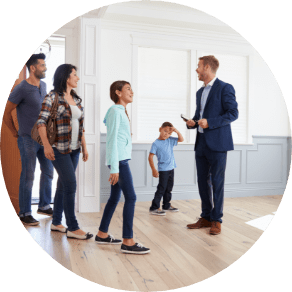 A family of four walking into a new home with realtor