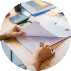 A desk with someone sorting through a stack of paper